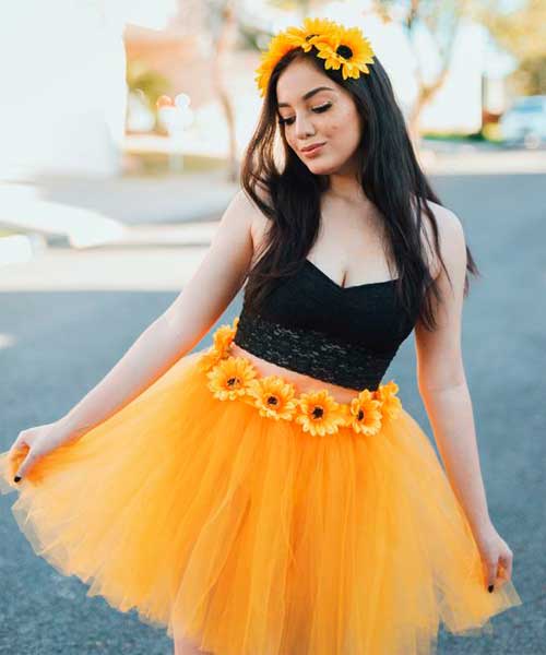 Disfraz de mujer con una falda de tul amarilla y flores