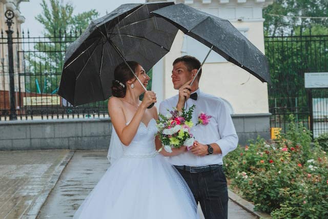 Marido y mujer con paraguas y lluvia